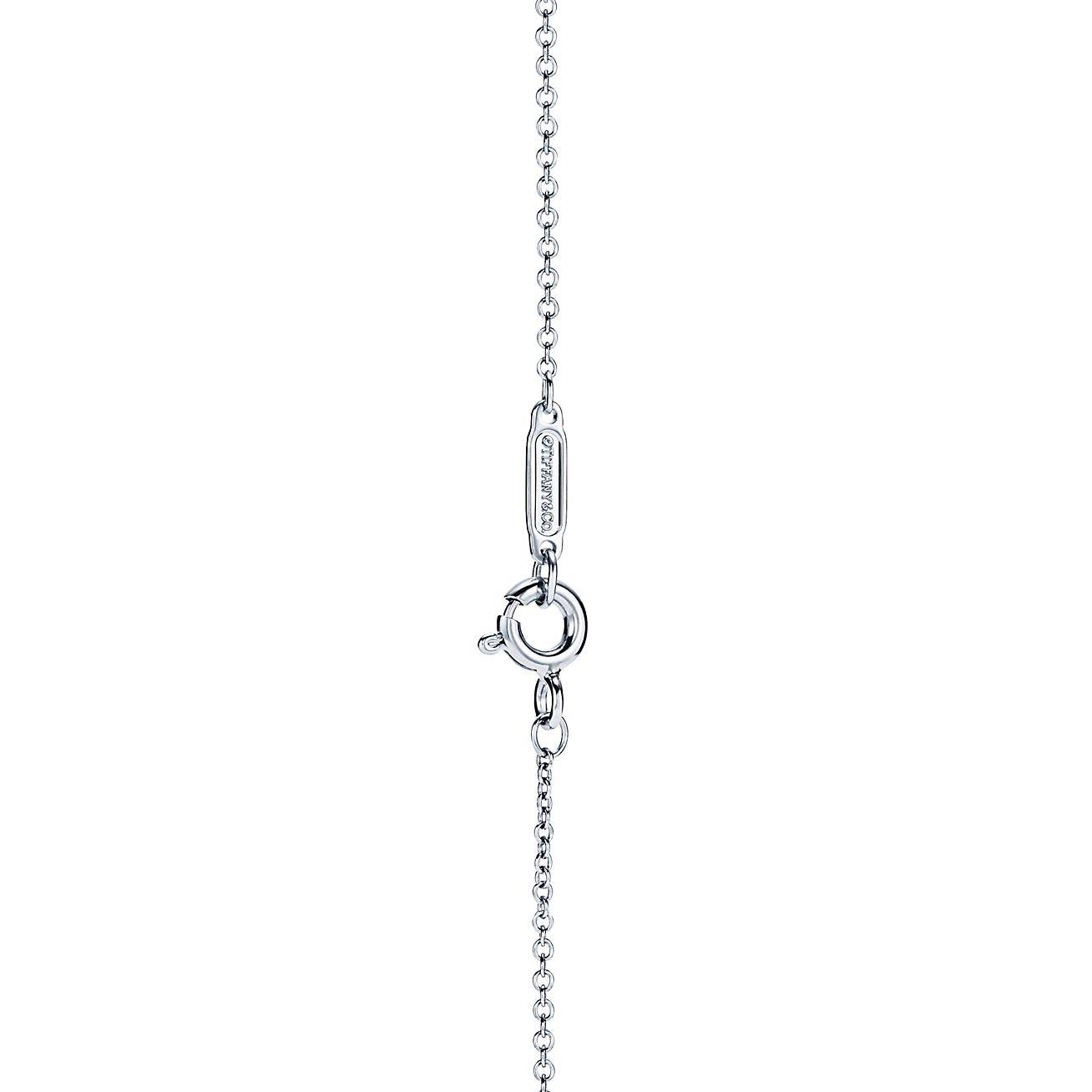 T*f*ny t diamond pendant in 18k white gold with a baguette diamond